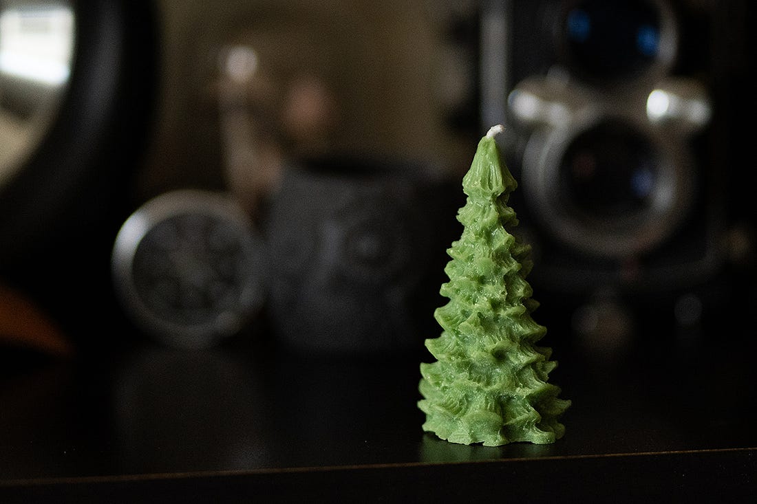 A photograph of a candle shaped like a Christmas tree