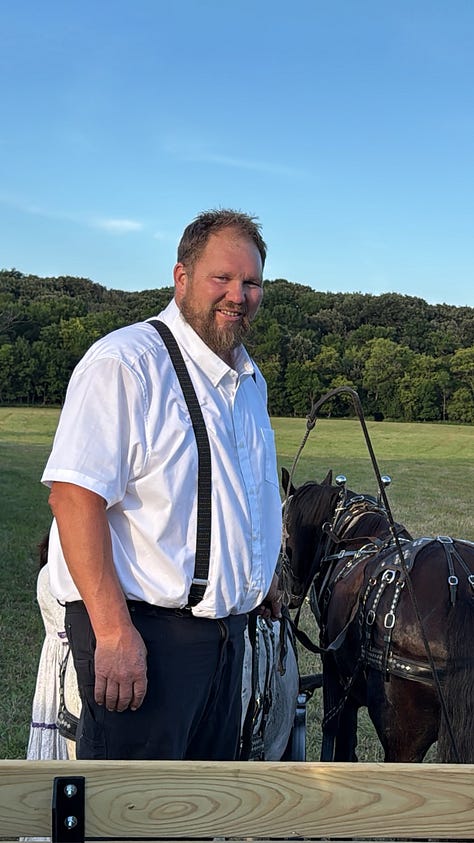 A man in suspenders poses with his horses. | Families try on bonnets at a Mercantile. | A white horse waits patiently to begin a quick wagon ride.