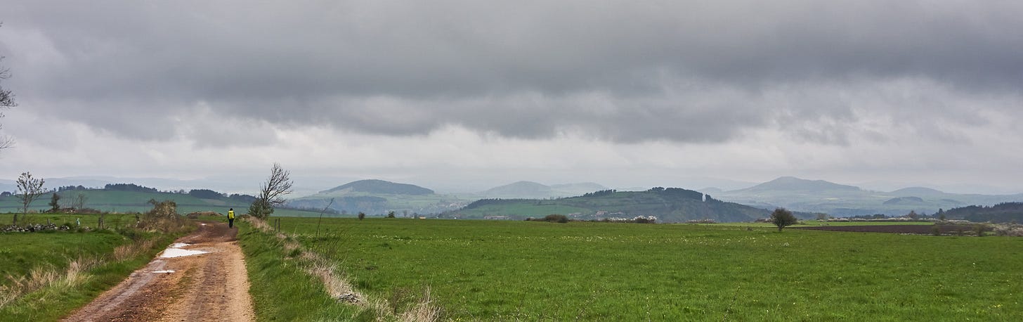 grassy plateau, gently rounded hills, low rainclouds