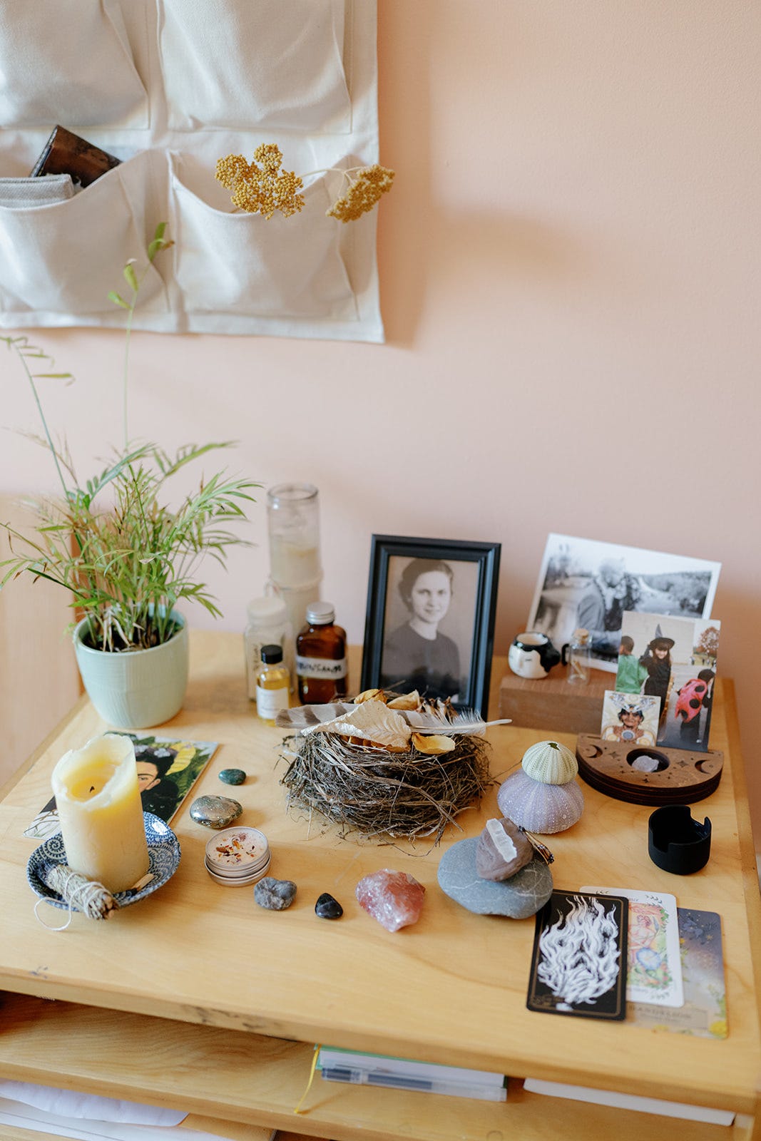 An image of photos, stones and collected items arranged on a wooden desk surface. 