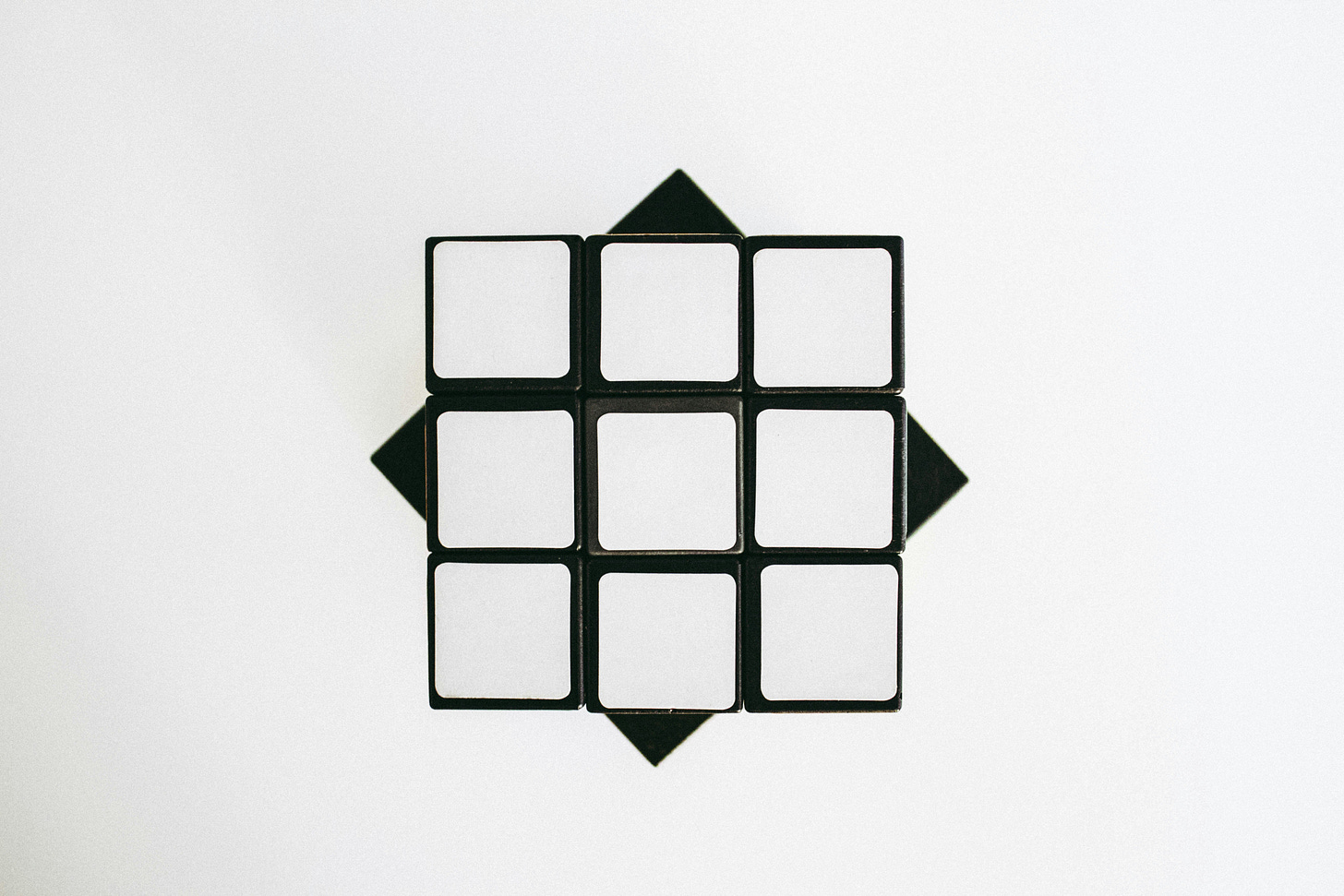 cubo di <rubik con tessere tutte bianche su struttura nera e fondo bianco