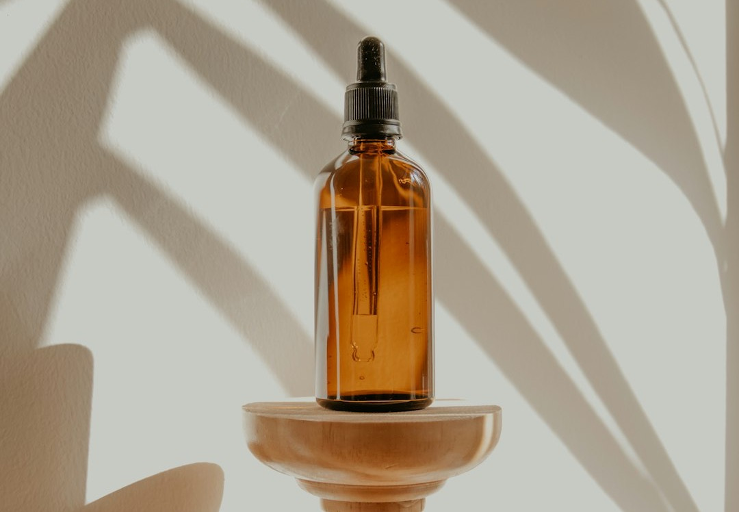 gold and black bottle on white wooden table
