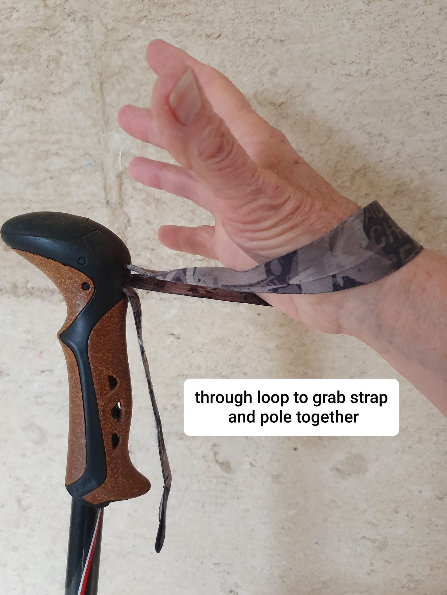 hand pasing up though wrist loop, about to grab pole handle