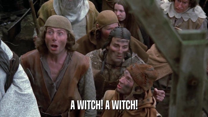 Still from "The Holy Grail" by Monty Pythin showing Erice Idle and John Clees shouting "A witch, a witch!"