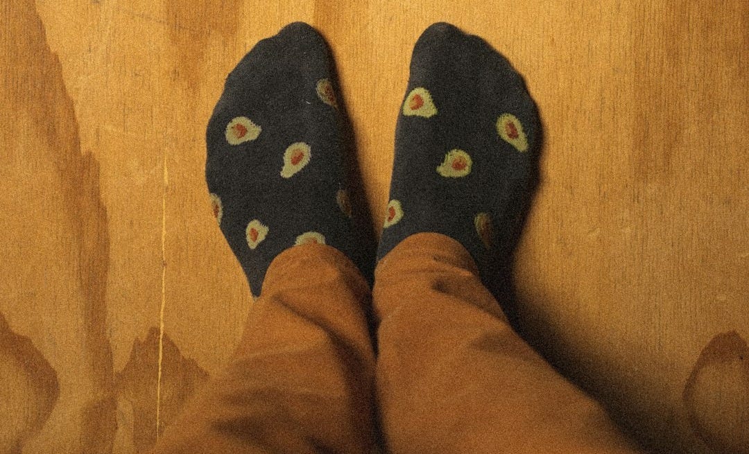 person wearing blue and yellow rubber clogs