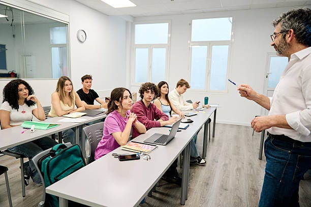 Professor teaching university students during lecture in modern classroom