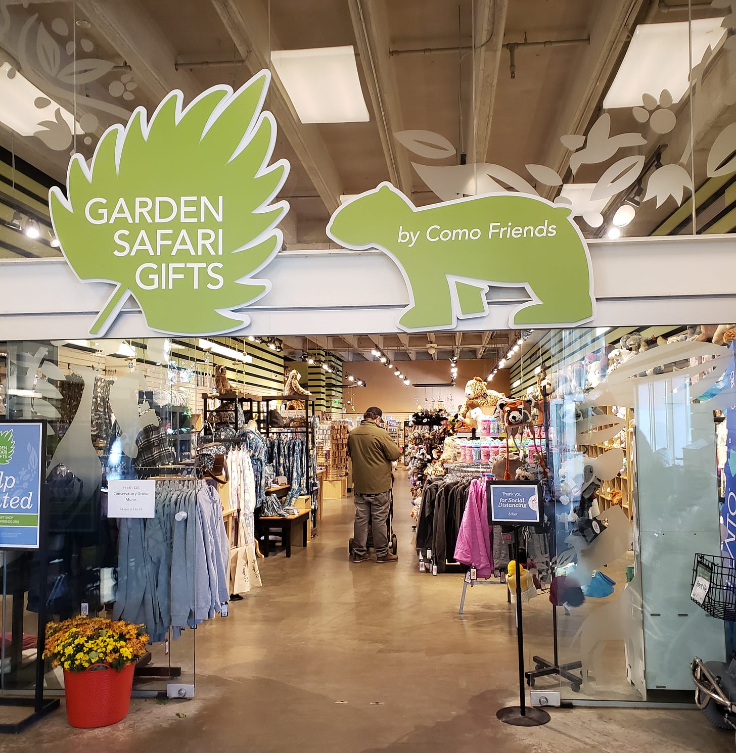 The door to the Garden Safari Gifts with the sign above it that reads the same and a polar bear shaped sign that reads by Como Friends.
