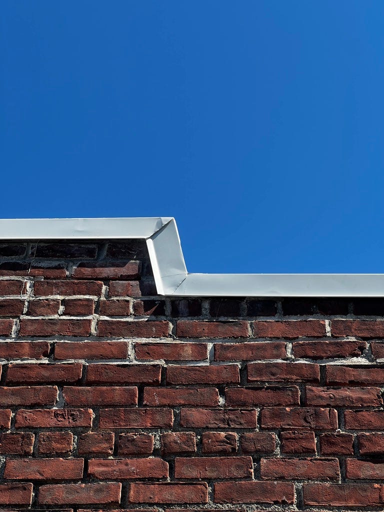 a brick wall below a bright blue sky