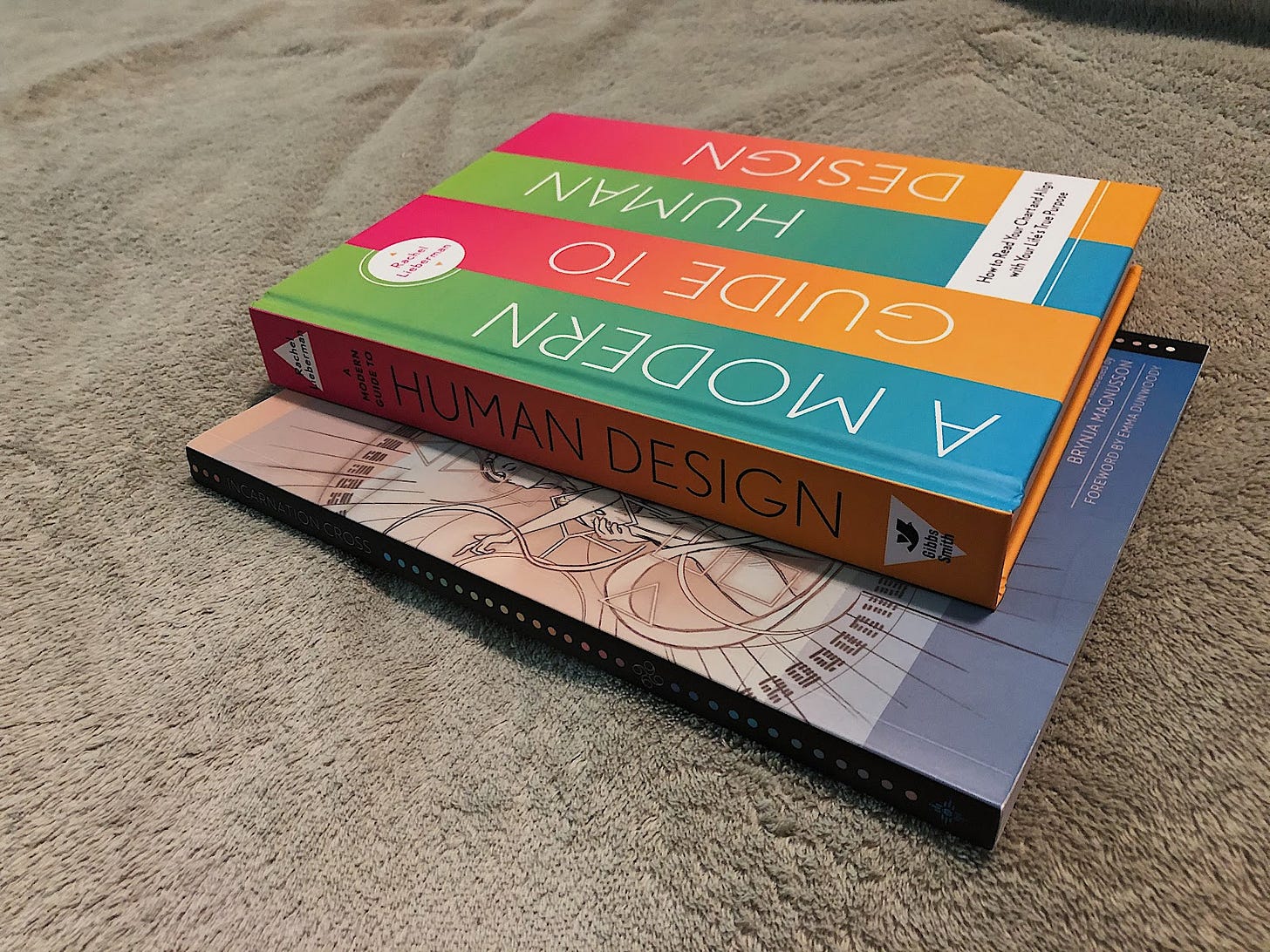 Two Human Design books stacked on a fuzzy green blanket