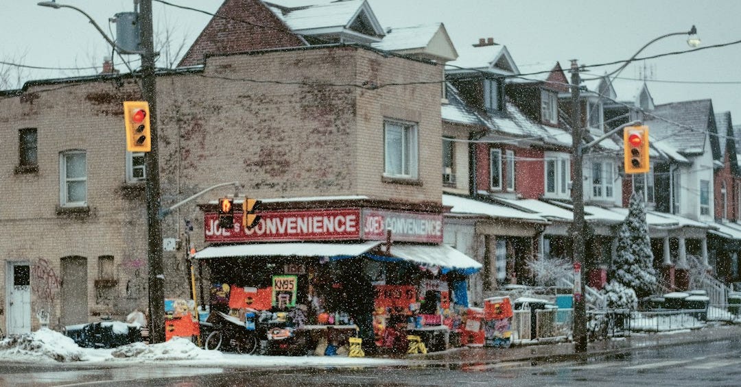 a street corner with a store on a snowy day a street corner with a store on a snowy day