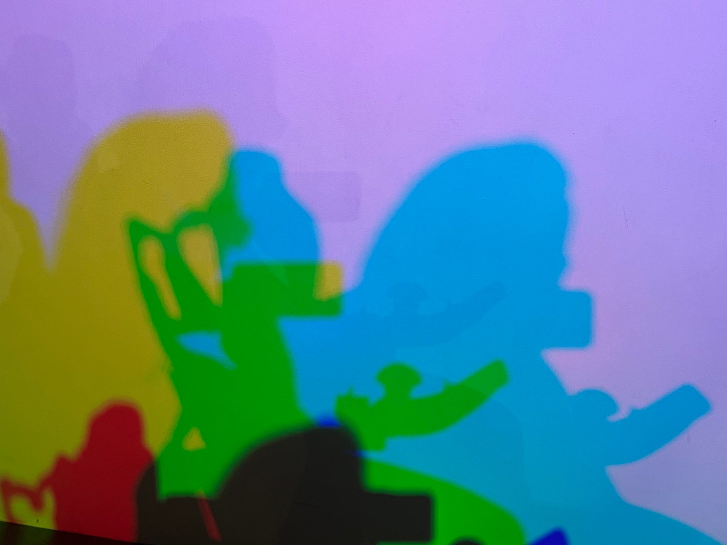Multiple shadows of a power wheelchair lit up in different colors