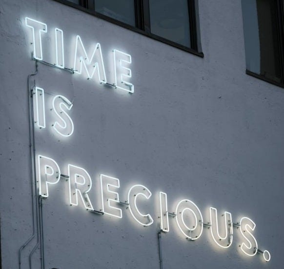 a neon sign that reads time is precious