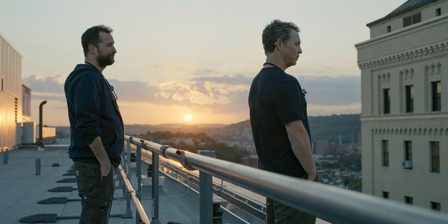Dr. Robby (Noah Wyle) and Dr. Abbot looking at the view from the roof in The Pitt Season 1 Ep 1