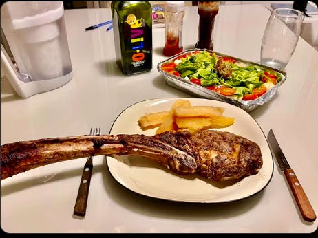 A plate of meat and fries on a table

Description automatically generated