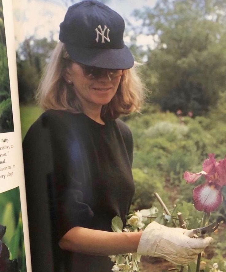 This may contain: a woman in a baseball cap is holding flowers