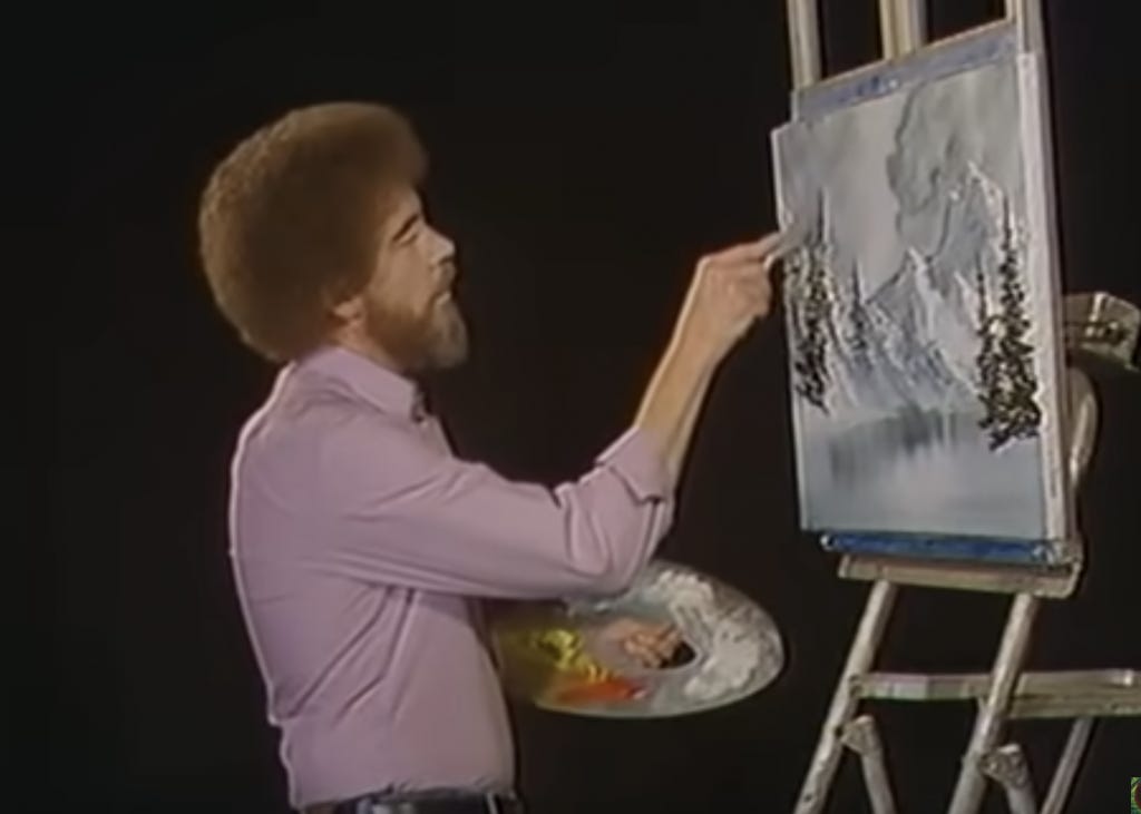 Bob Ross painting snowy mountain landscape on The Joy of Painting TV show, using palette knife technique in front of black backdrop.