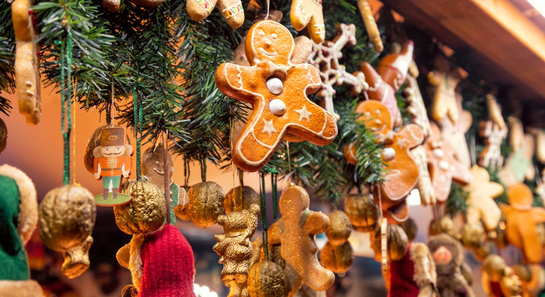 A collection of gingerbread and gold treats hanging from ribbon A collection of gingerbread and gold treats hanging from ribbon