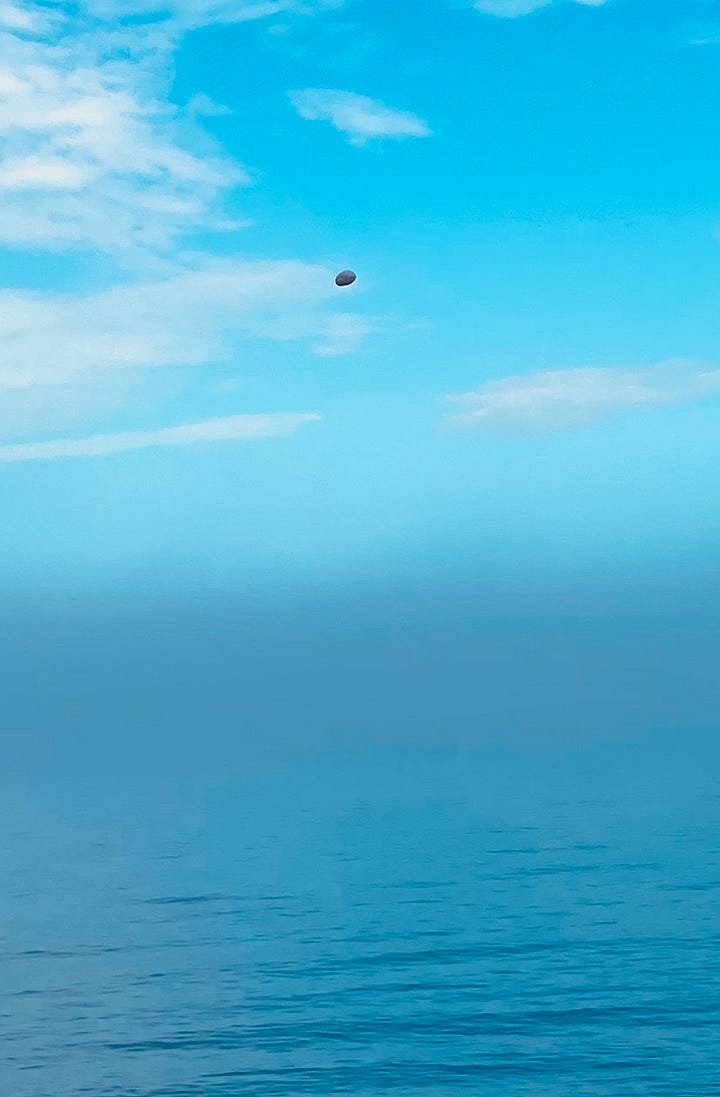 two pictures of a calm, blue ocean with a zoom in of a white rock in the air