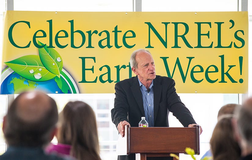 Denis Hayes speaks at a podium. A sign with the words Celebrate NREL's Earth Week! is behind him. Denis Hayes speaks at a podium. A sign with the words Celebrate NREL's Earth Week! is behind him.