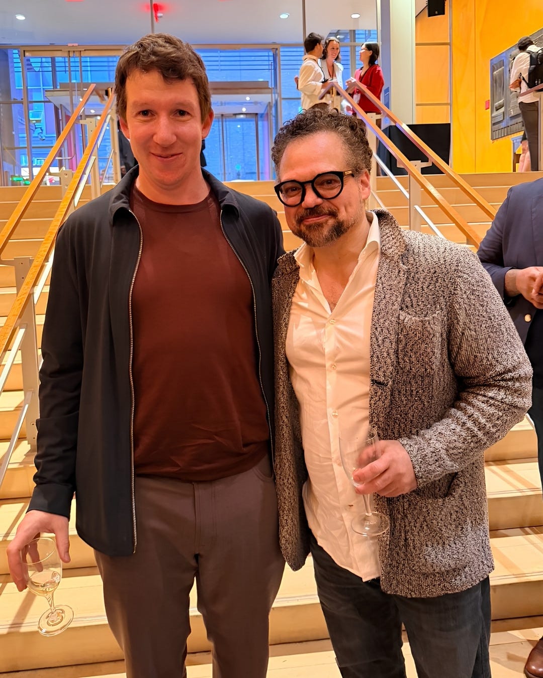 Jack Clark (Anthropic) and Roger Santodomingo (The Aspen Institute) on the Times Center stairs, holding wine cups and smiling. Jack Clark (Anthropic) and Roger Santodomingo (The Aspen Institute) on the Times Center stairs, holding wine cups and smiling.