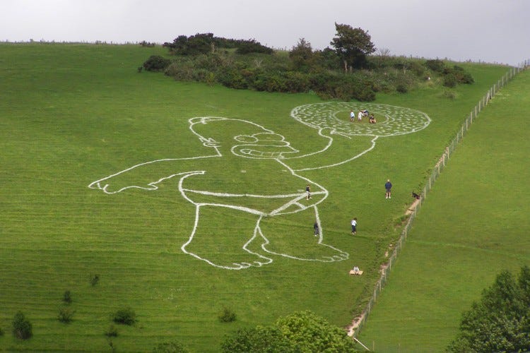 A photo of a gigantic homer simpson in Y fronts brandishing a donut, painted white on a Dorset hillside A photo of a gigantic homer simpson in Y fronts brandishing a donut, painted white on a Dorset hillside