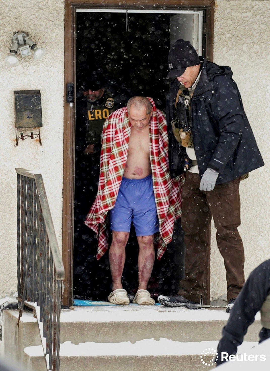 Elderly man wearing only shorts with a blanket over his shoulders is flanked by ICE officers on either side as he descends the front stairs of him home in the snow.

“A man, whose family requested a Hmong interpreter, is detained after ICE agents and other law enforcement officers conducted an immigration raid at his home, days after an ICE agent fatally shot Renee Nicole Good, in St. Paul, Minnesota, U.S., January 18, 2026.REUTERS/Leah Millis”

via @idreesali114.bsky.social on X
