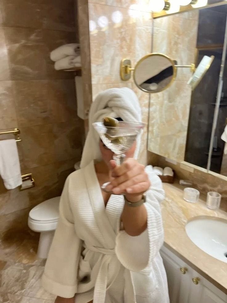 This may contain: a woman in a bathrobe taking a selfie