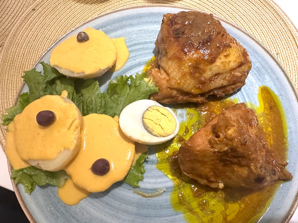 Plate with potatoes in a yellow a la huancaina sauce and chicken in red pepper sauce