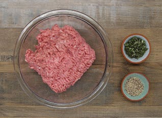 Bowl with 1 pound ground turkey and smaller bowls with chopped sage and rancher steak rub Bowl with 1 pound ground turkey and smaller bowls with chopped sage and rancher steak rub