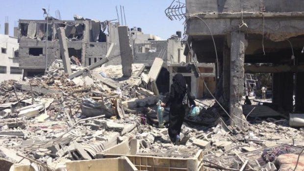 Nissana Sukar in the rubble outside her home in Shujaiyah. Nissana Sukar in the rubble outside her home in Shujaiyah.