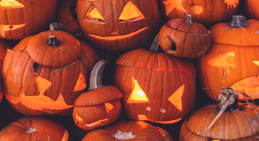 A group of pumpkin jack-o-lanterns with lit eyes