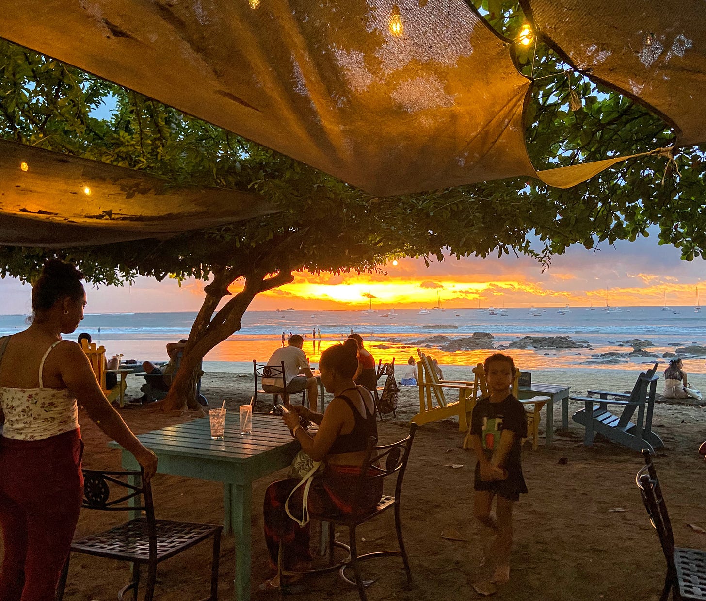 sunset on the beach, with table and chairs in foreground