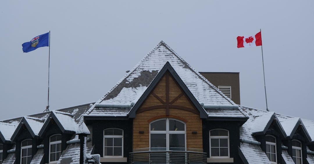 Canadian and provincial flags on snowy building Canadian and provincial flags on snowy building