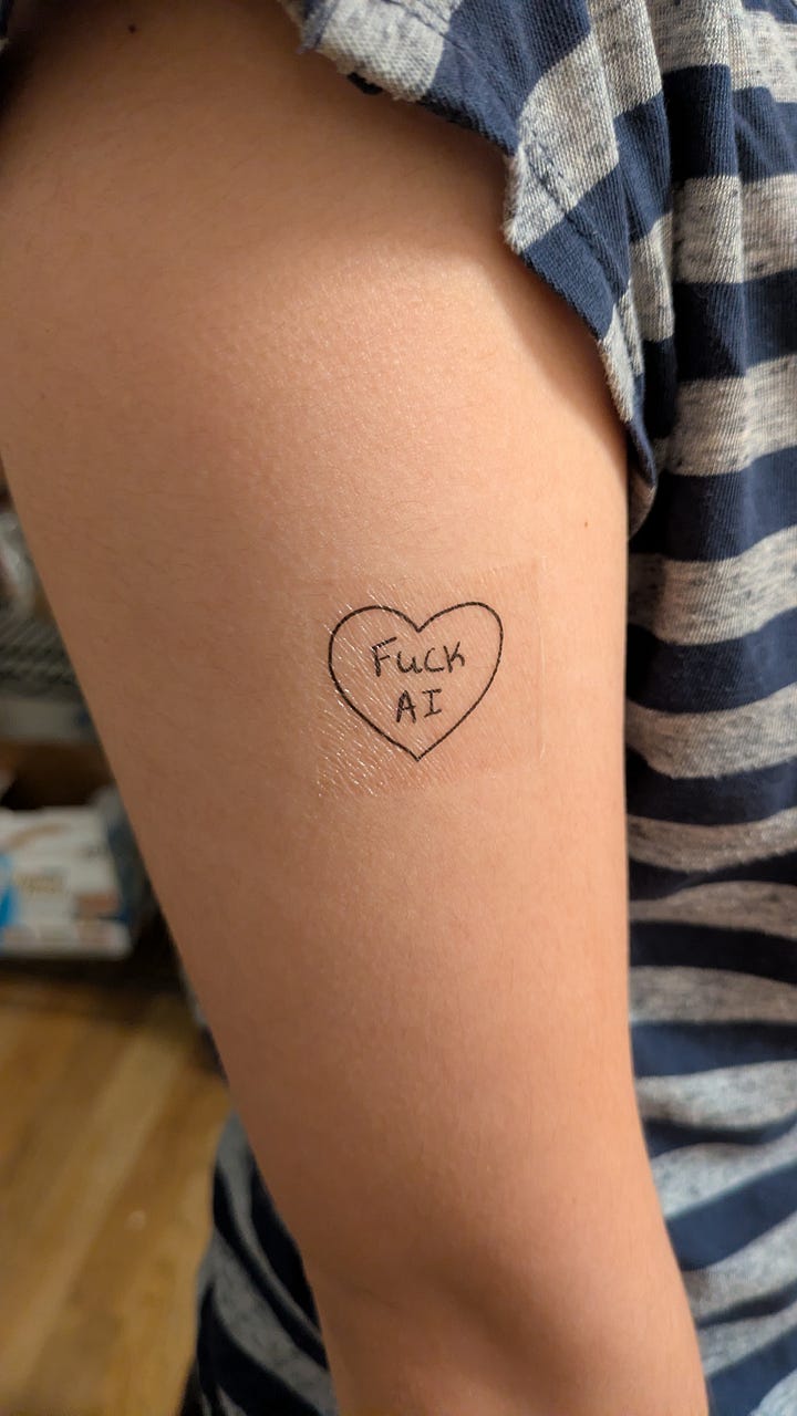 Left: pile of temporary tattoos on a table, Right: Temporary tattoo that says "Fuck AI" on an arm