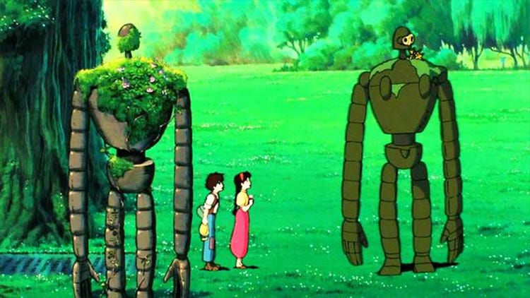 Two robots covered in moss standing in a grassy field with two children.