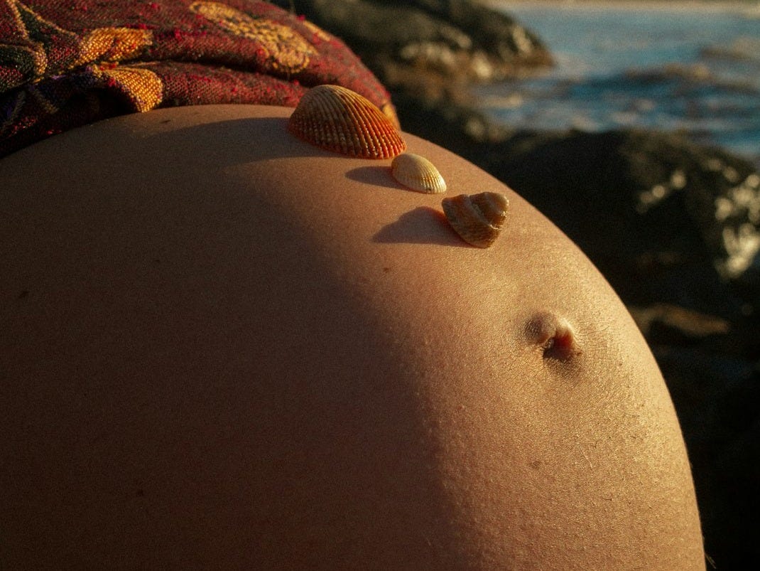 A pregnant woman with seashells on her belly