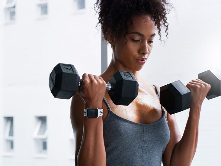 Strong female doing dumbbell curls in the gym. Strong female doing dumbbell curls in the gym.