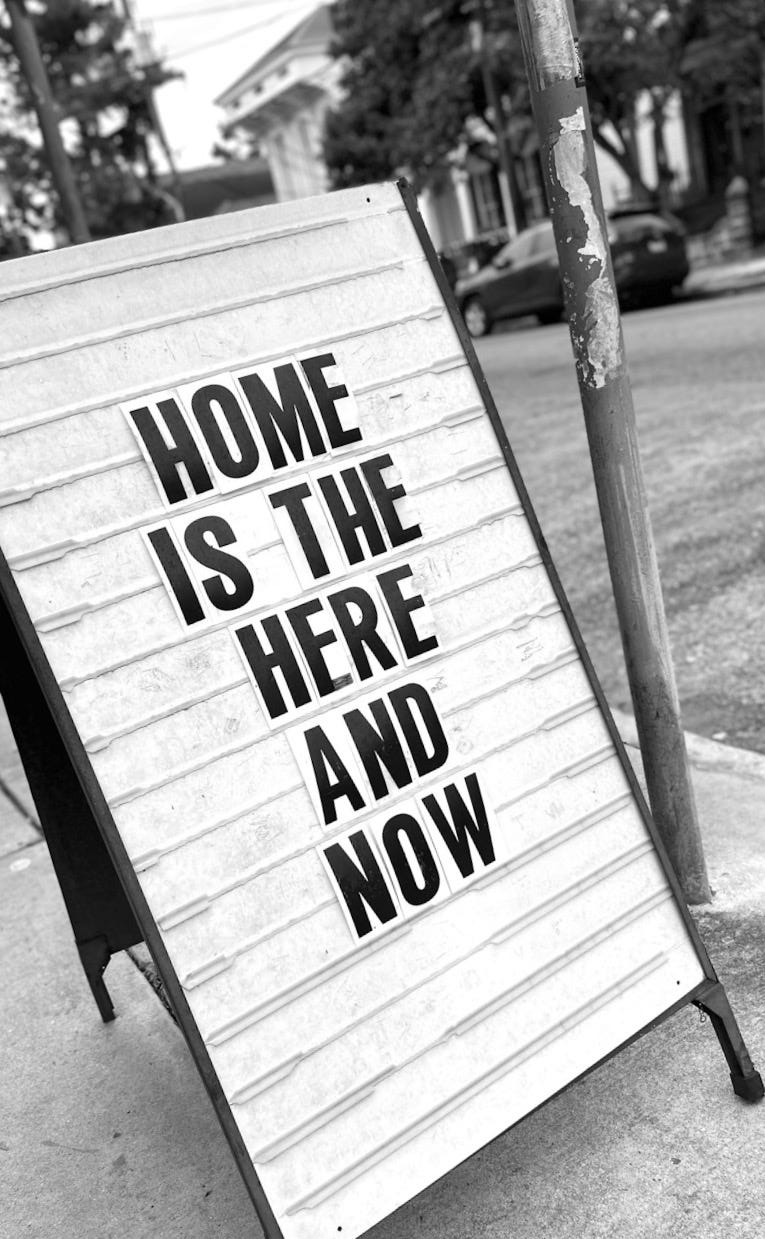 a sign on a sidewalk that says home is the here and now a sign on a sidewalk that says home is the here and now