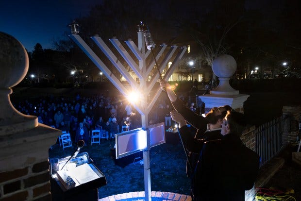 Rabbi Mendy Heber lights a menorah on the first night of Hanukkah during a lighting ceremony on Dec. 7, 2023 at the Sunken Gardens on the campus of William & Mary University in Williamsburg, Virginia. Heber was turned down to hold a menorah lighting ceremony at the 2nd Sundays festival, and instead scheduled it at the Sunken Gardens, where he also held the ceremony in 2021.(Billy Schuerman / The Virginian-Pilot) Rabbi Mendy Heber lights a menorah on the first night of Hanukkah during a lighting ceremony on Dec. 7, 2023 at the Sunken Gardens on the campus of William & Mary University in Williamsburg, Virginia. Heber was turned down to hold a menorah lighting ceremony at the 2nd Sundays festival, and instead scheduled it at the Sunken Gardens, where he also held the ceremony in 2021.(Billy Schuerman / The Virginian-Pilot)
