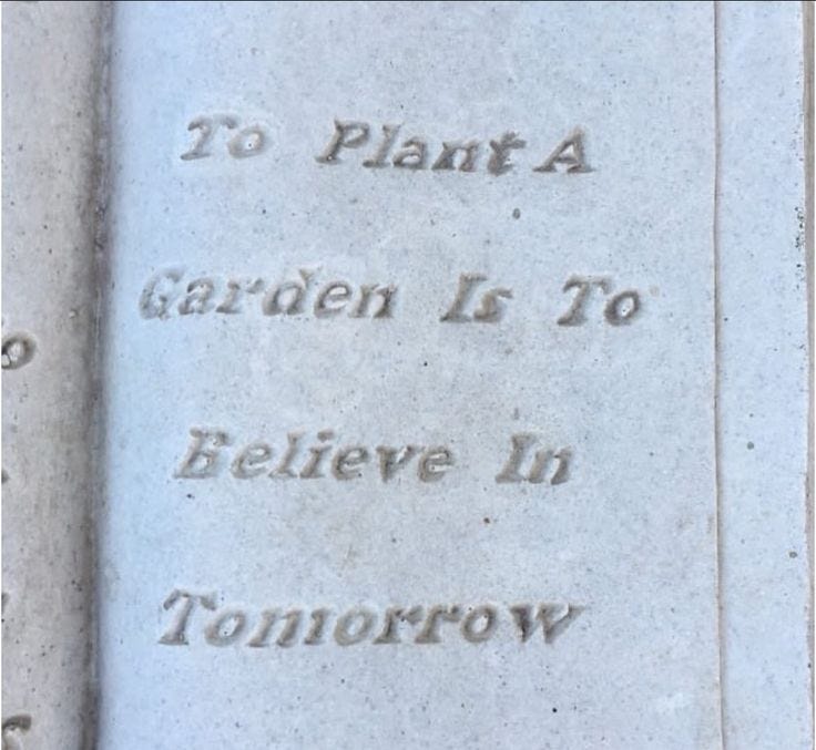 This may contain: there is a plaque that says to plant a garden is to believe in tomorrow