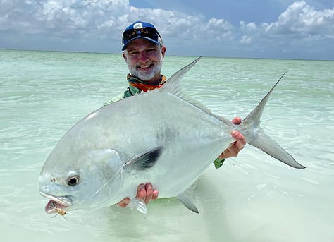 angler with large permit standing in the water