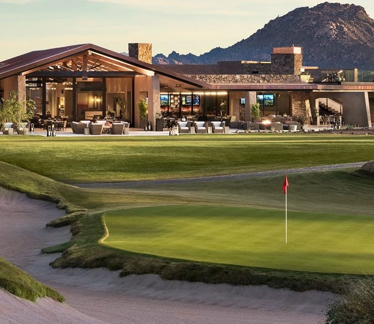 This may contain: a golf course with mountains in the background This may contain: a golf course with mountains in the background
