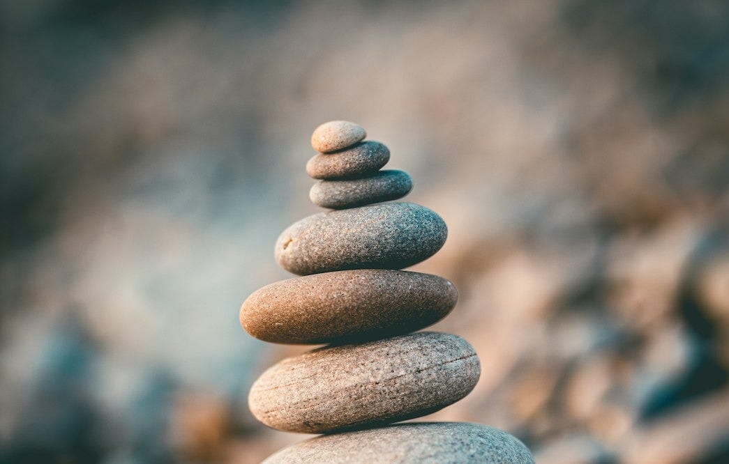 a stack of rocks sitting on top of a rocky beach a stack of rocks sitting on top of a rocky beach