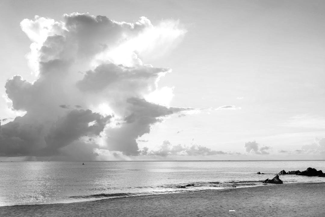 a large cloud is in the sky over a beach