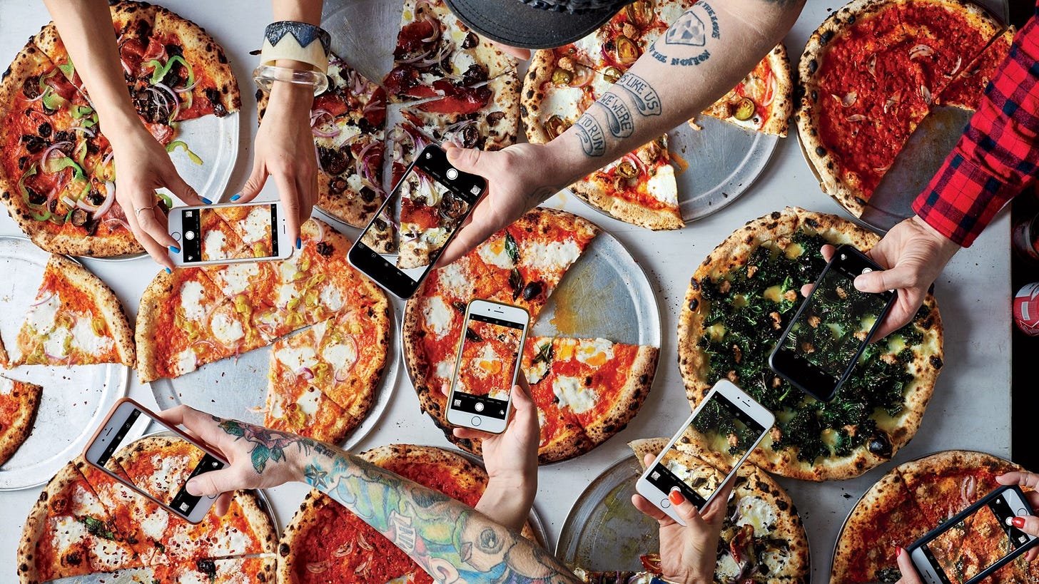 Mani che fotografano pizze dall'alto