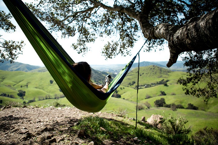 Relaxing hammock. Coins stacking like compound interest. Photos by Austin Schmid and Marcus Strauss via Unsplash.