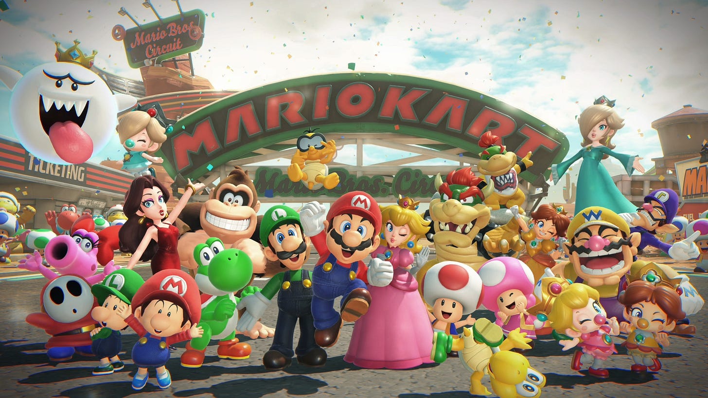 Mario and friends pose for a picture in front of a Mario Kart overhang.