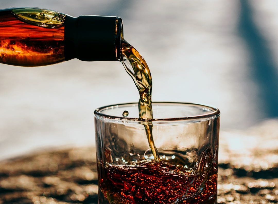 clear drinking glass with brown liquid