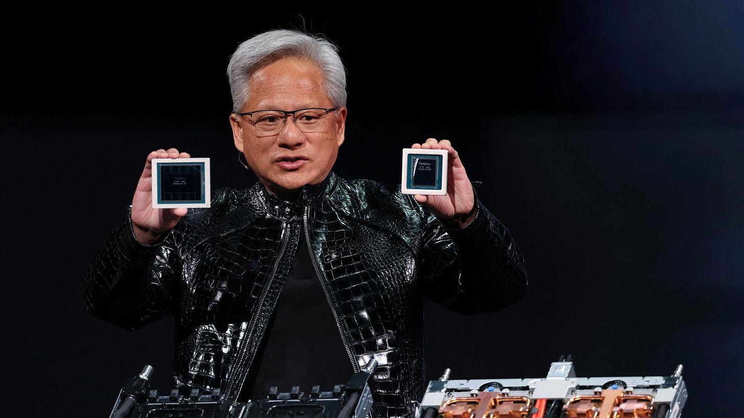 Nvidia CEO Jensen Huang, on a stage in a black leather jacket, holding two computer chips in his hands. Nvidia CEO Jensen Huang, on a stage in a black leather jacket, holding two computer chips in his hands.