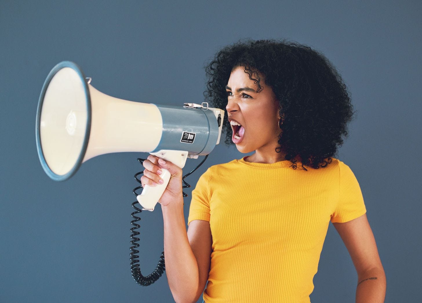 Women screaming into a megaphone. Photo courtesy of LaylaBird via Canva.